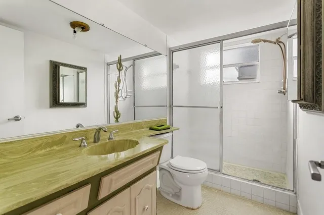 a bathroom with a granite countertop sink toilet and shower