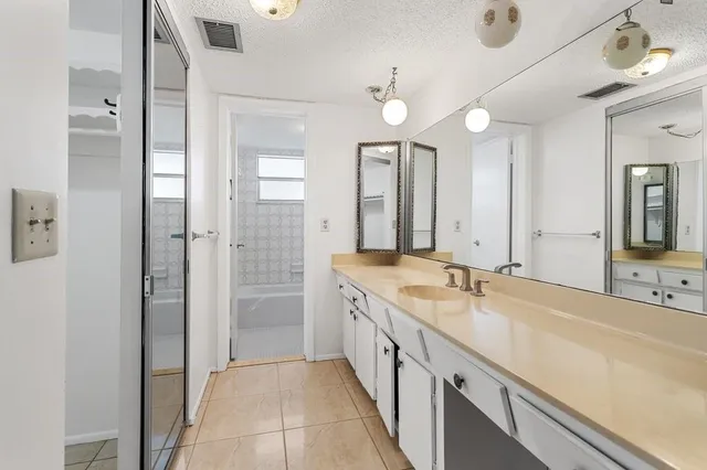 a large bathroom with a double vanity sink a large mirror and a shower