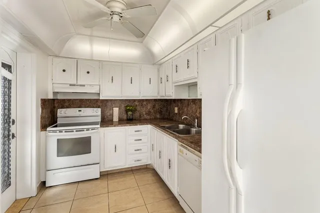 a kitchen with white cabinets and white appliances