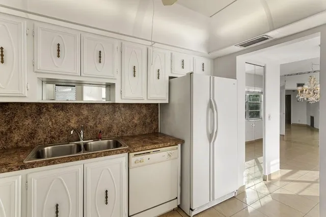 a kitchen with stainless steel appliances white cabinets and a refrigerator