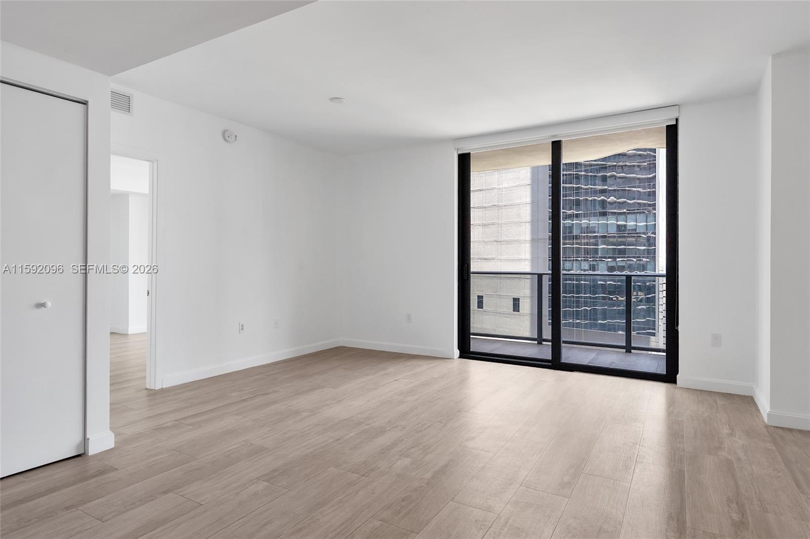 45 Southwest 9th Street, Unit 3502 Miami, FL 33130 - Photo 12 of 46 a view of an empty room with wooden floor and a window