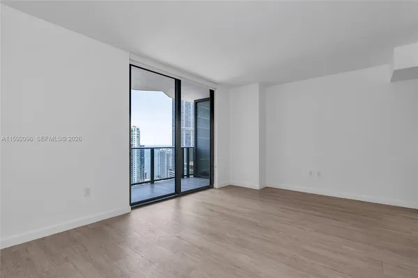 an empty room with wooden floor and sliding door