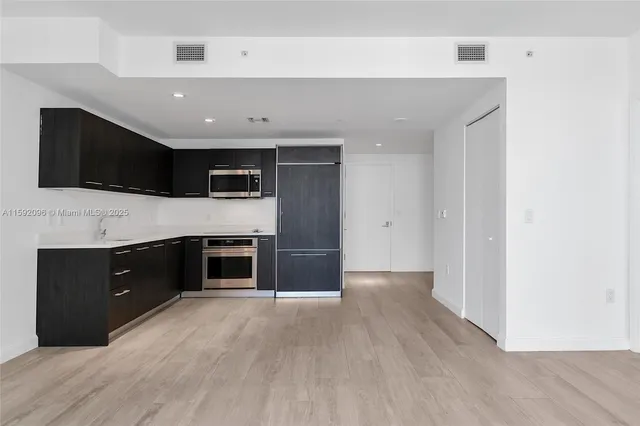 a spacious bedroom with a bed and a flat screen tv