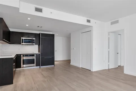 a kitchen with stainless steel appliances granite countertop a refrigerator and a stove top oven