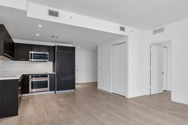a kitchen with stainless steel appliances granite countertop a refrigerator and a stove top oven