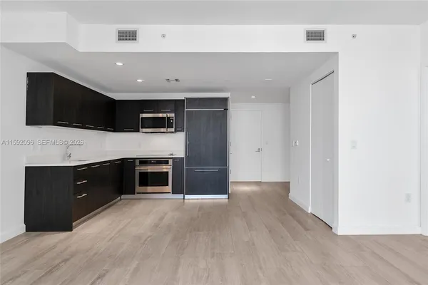 a view of a kitchen with a sink and a refrigerator