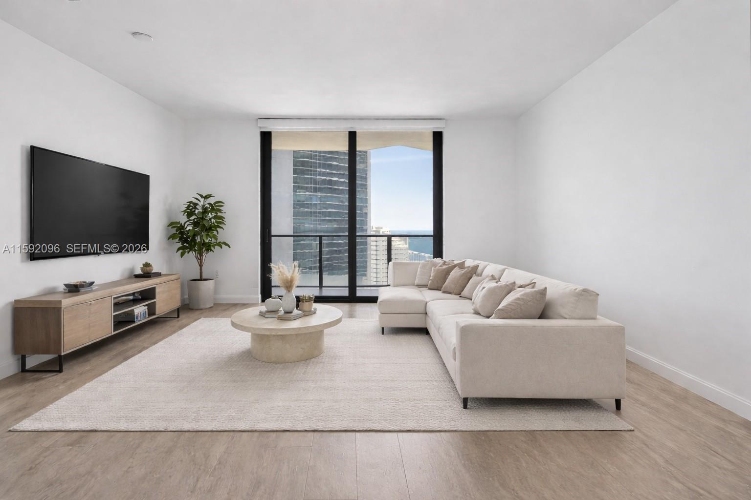 45 Southwest 9th Street, Unit 3502 Miami, FL 33130 - Photo 2 of 46 a living room with furniture and a flat screen tv