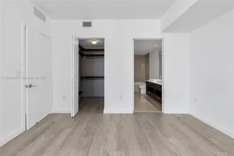 an empty room with wooden floor and closet