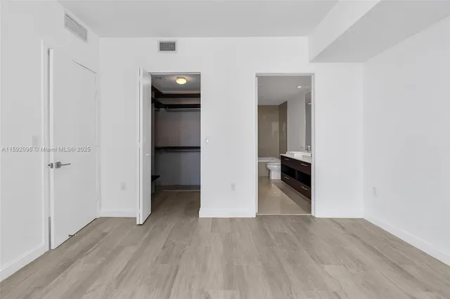an empty room with wooden floor and closet