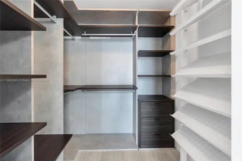 a view of walk in closet with empty racks