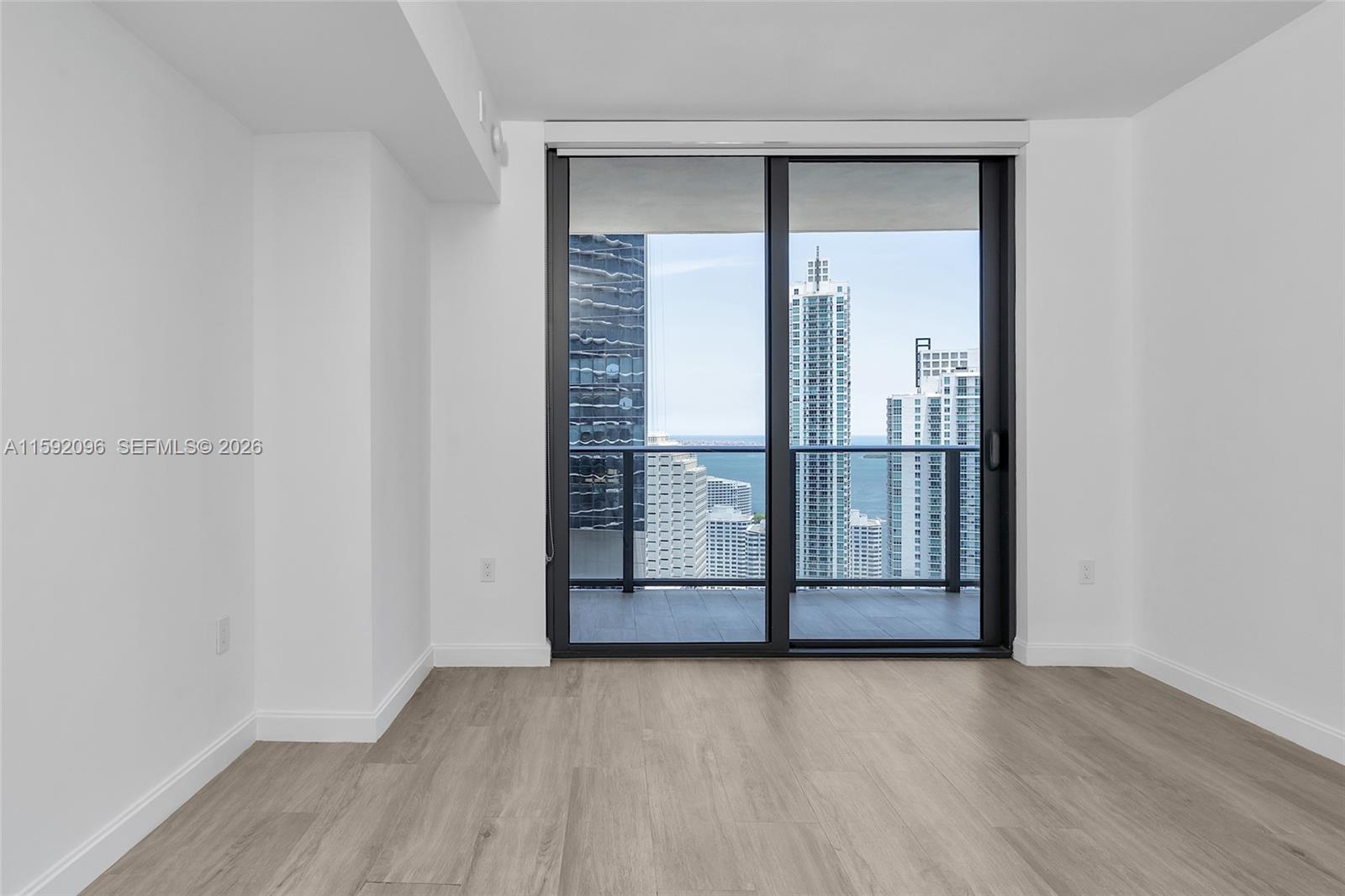 45 Southwest 9th Street, Unit 3502 Miami, FL 33130 - Photo 24 of 46 an empty room with wooden floor and door