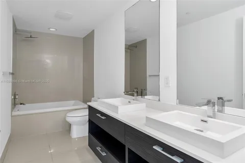a bathroom with a double vanity sink toilet and a bathtub