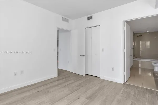 an empty room with wooden floor and closet