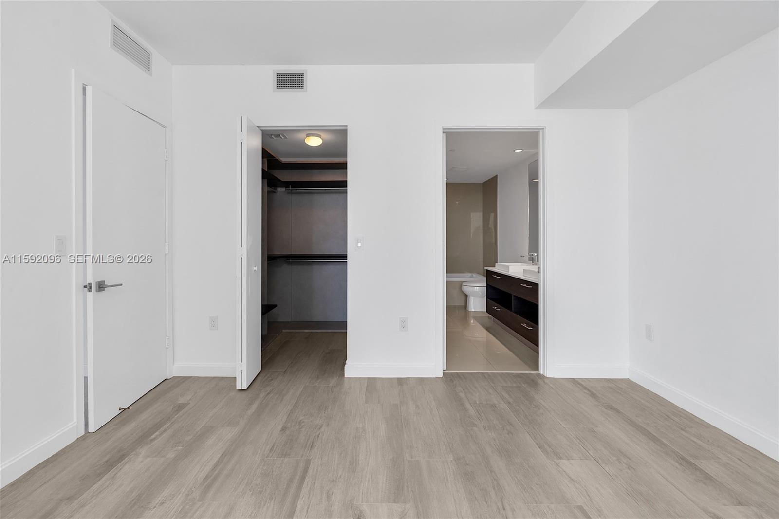 45 Southwest 9th Street, Unit 3502 Miami, FL 33130 - Photo 26 of 46 an empty room with wooden floor and closet