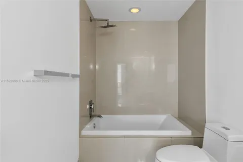 a bath room with a toilet and a bath tub
