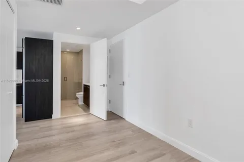 a view of a hallway with wooden floor and closet area