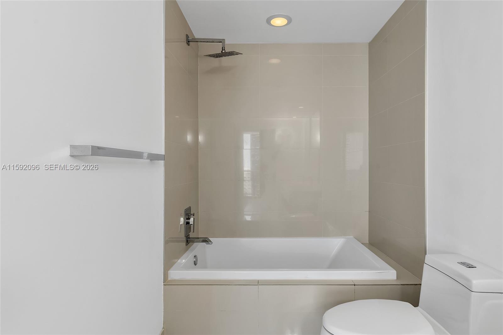 45 Southwest 9th Street, Unit 3502 Miami, FL 33130 - Photo 30 of 46 a bath room with a toilet and a bath tub