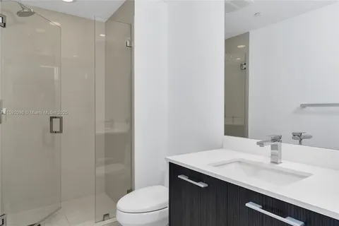 a bathroom with a sink toilet vanity and shower