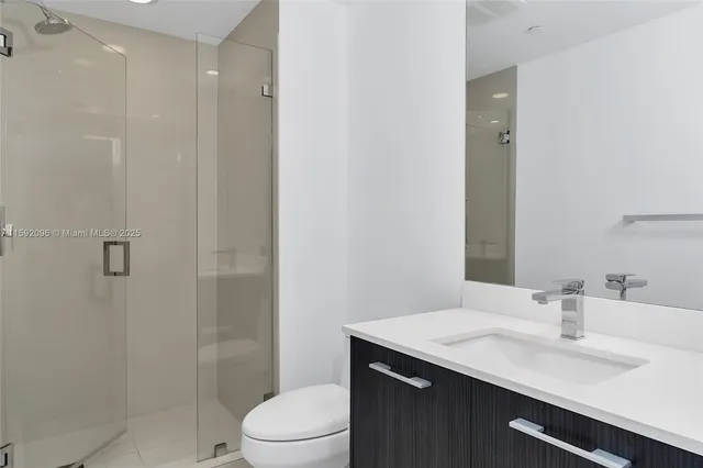 a bathroom with a sink toilet vanity and shower