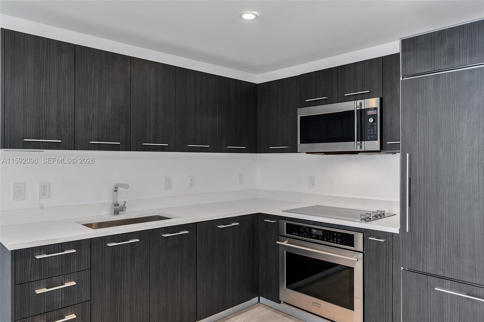 45 Southwest 9th Street, Unit 3502 Miami, FL 33130 - Photo 9 of 46 a kitchen with a sink stove and microwave
