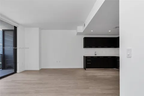 a view of an empty room with a fireplace and a flat screen tv