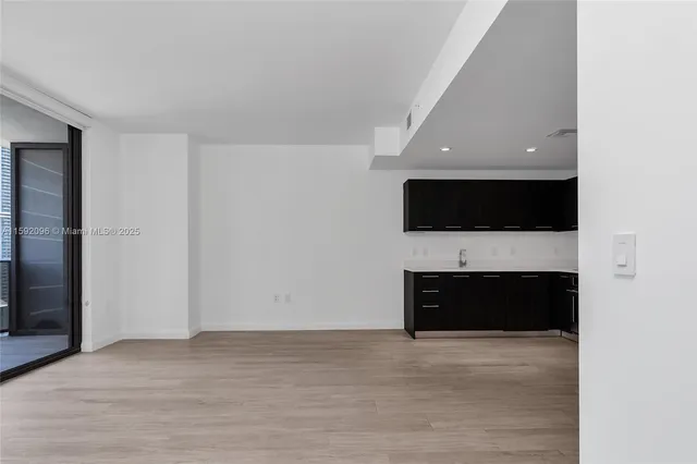 a view of an empty room with a fireplace and a flat screen tv