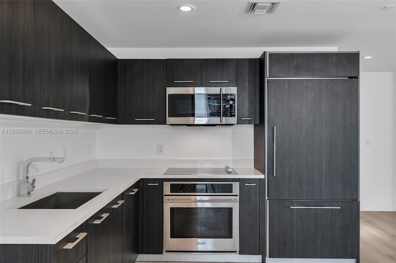 45 Southwest 9th Street, Unit 3502 Miami, FL 33130 - Photo 10 of 46 a kitchen with a sink and a microwave