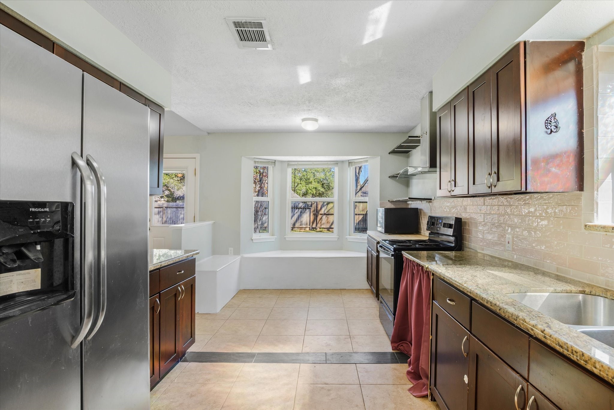 4905 Woodway Avenue Rosenberg, TX 77471 - Photo 13 of 30 a kitchen with granite countertop stainless steel appliances a refrigerator stove top oven and sink