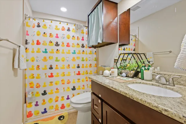 a bathroom with a granite countertop sink a toilet and a mirror
