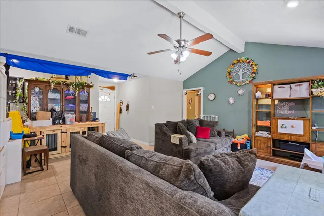a living room with stainless steel appliances furniture and a chandelier