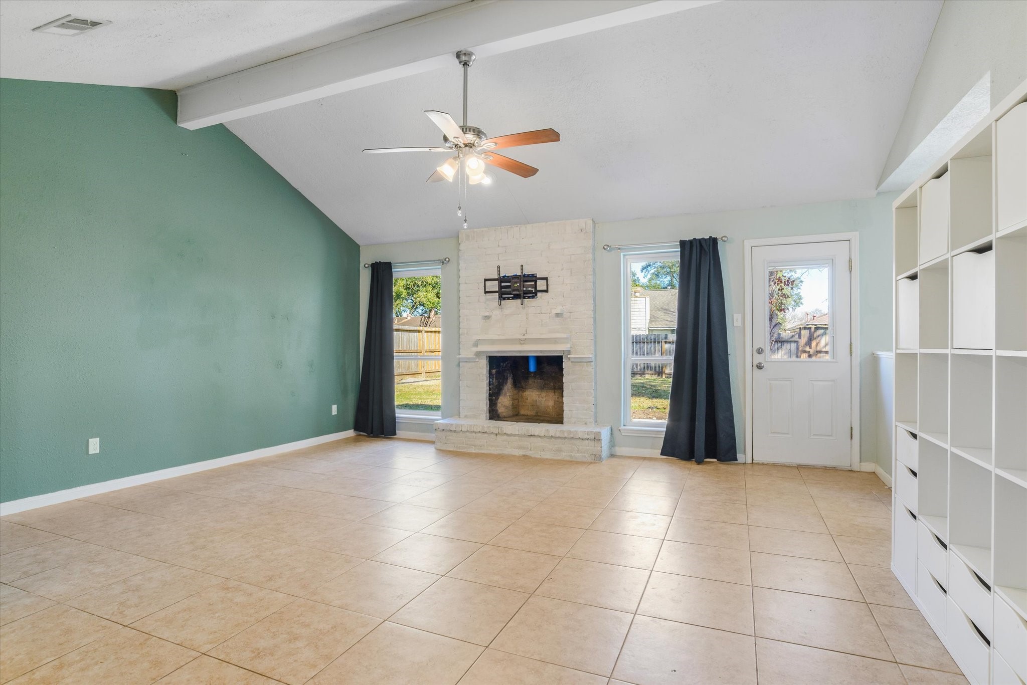 4905 Woodway Avenue Rosenberg, TX 77471 - Photo 5 of 30 a view of an empty room with a fireplace and a chandelier fan