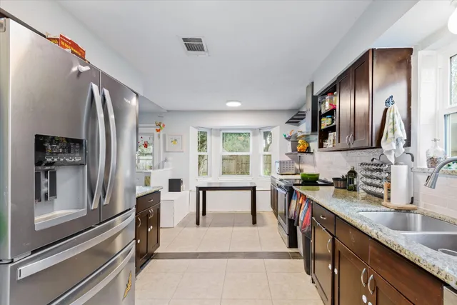 a kitchen with stainless steel appliances granite countertop sink stove and refrigerator