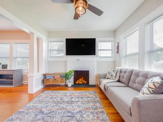 a living room with furniture a flat screen tv and a fireplace
