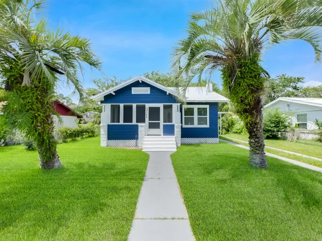 a front view of a house with a garden and yard