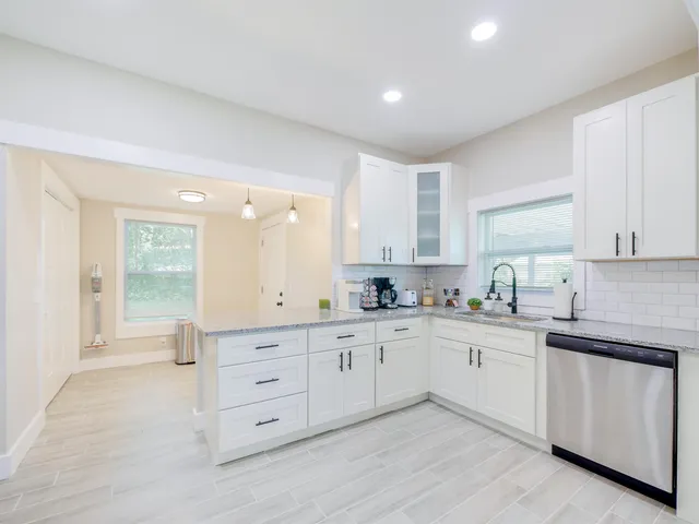 a kitchen with white cabinets and sink
