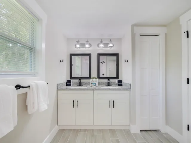 a bathroom with a granite countertop sink and a mirror