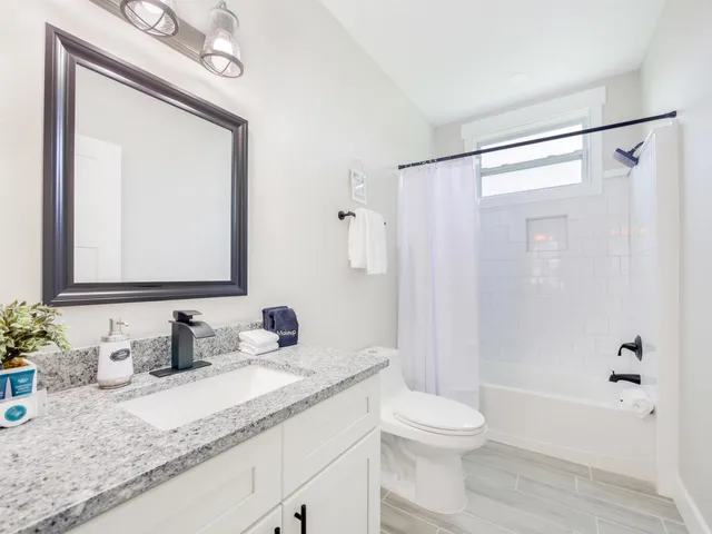 a bathroom with a granite countertop sink toilet and shower