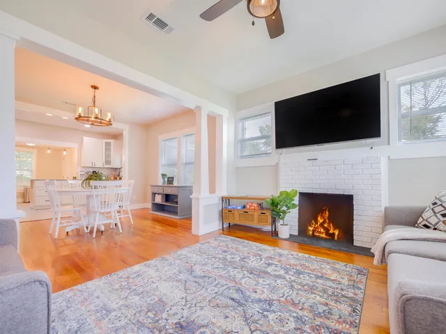 a living room with furniture a fireplace and a flat screen tv
