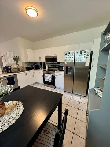 a kitchen with granite countertop a refrigerator a stove and a sink