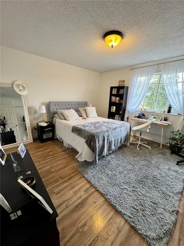 a bedroom with a bed and large windows