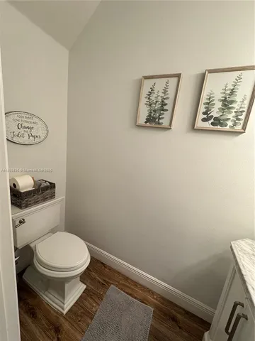 a white toilet sitting next to a white wall