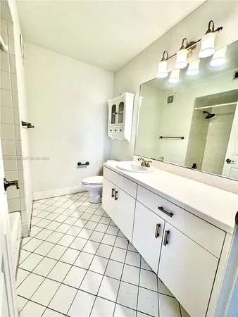 a bathroom with a sink mirror and toilet