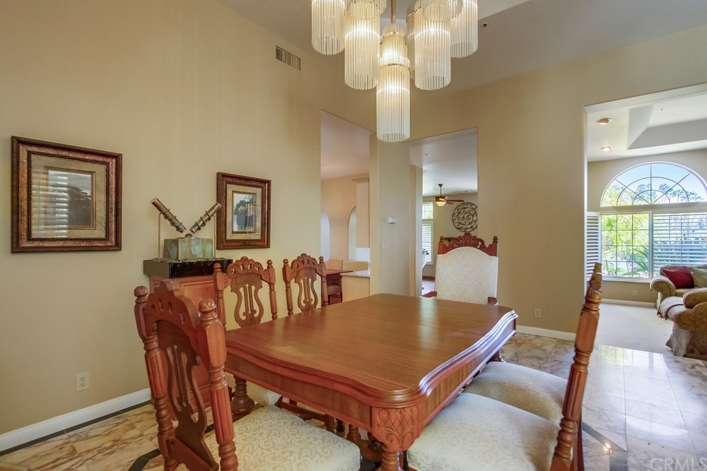 3036 Southwind Lane Vista, CA 92084 - Photo 15 of 45 a dining room with furniture a chandelier and wooden floor