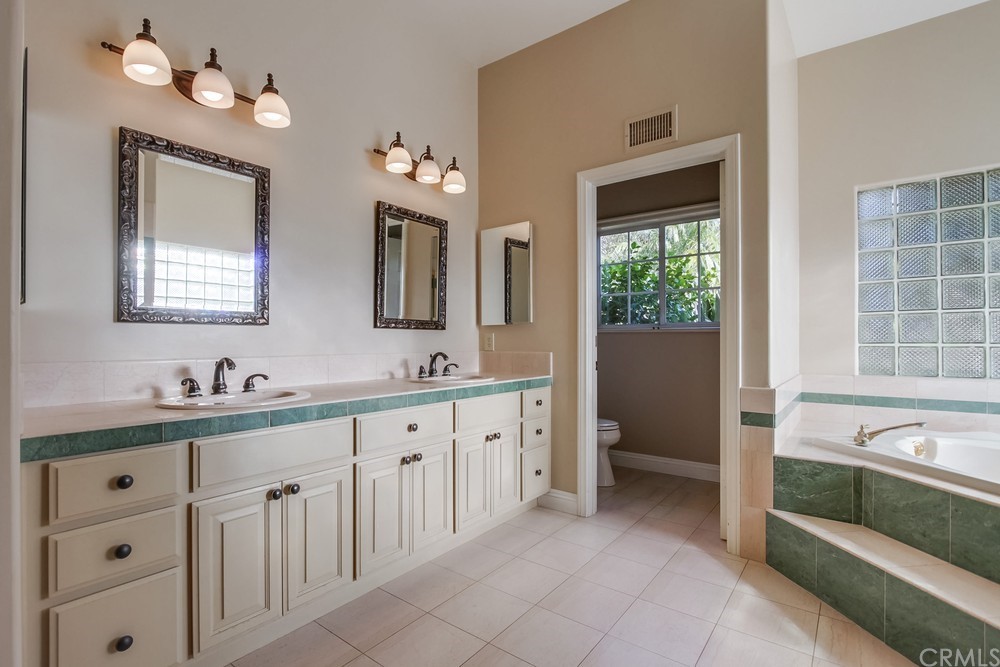 3036 Southwind Lane Vista, CA 92084 - Photo 28 of 45 a spacious en suite bathroom with a double vanity sink a large mirror and a bathtub