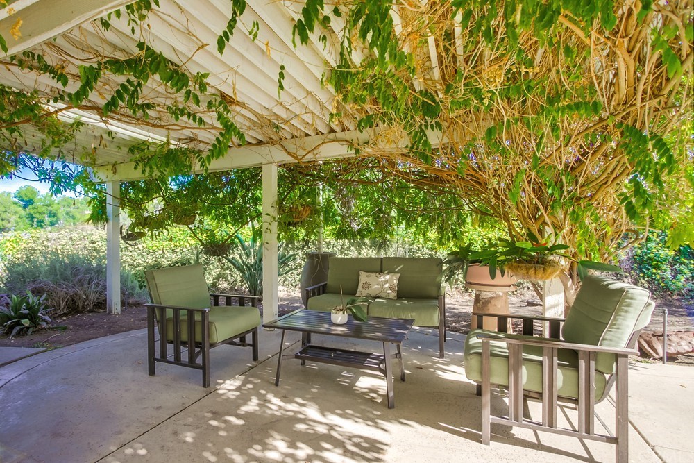 3036 Southwind Lane Vista, CA 92084 - Photo 10 of 45 a view of a patio with table and chairs and potted plants with large tree