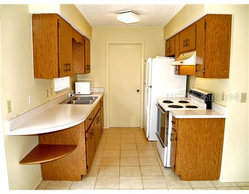 5281 Drew Road Venice, FL 34293 - Photo 8 of 12 Kitchen - Kitchen has wood cabinets, window at sink, door to garage.
