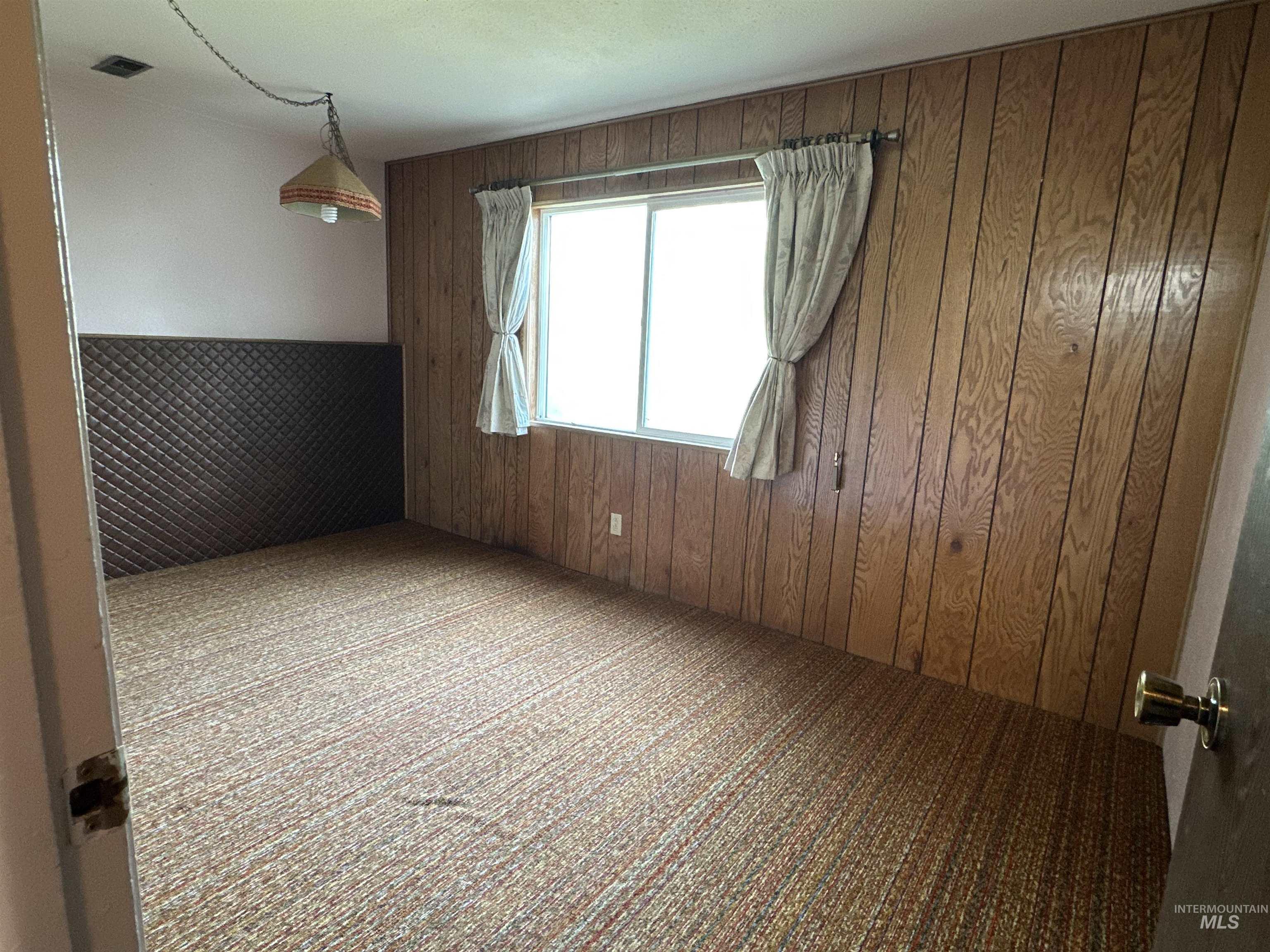 1620 6th Avenue Clarkston, WA 99403 - Photo 13 of 19 Interior room featuring wood paneling, a single window, and textile flooring