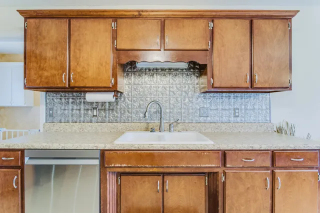 a kitchen with stainless steel appliances granite countertop a refrigerator a stove a sink and a microwave