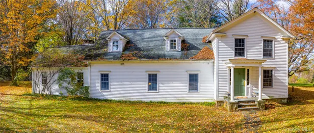a view of a house with large windows and a small yard