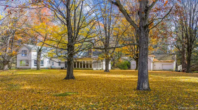 a front view of a house with a large tree